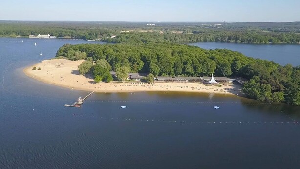 An aerial view of a coastal property with a beach, a pier, and a building surrounded by dense forest. - Holiday Apartment Am Linnert with Shared Terrace, Garden, and Wi-Fi (Haltern am See)