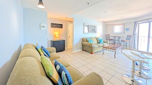 A living room with a sofa, a coffee table, a dining table, and a kitchen area. - Myrtle Beach Resort RT1915 (Myrtle Beach)