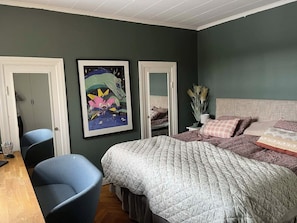 Une chambre à coucher avec un lit, une chaise, un bureau et deux portes.