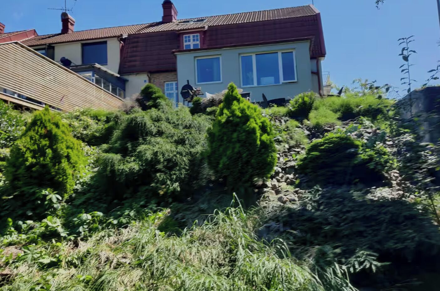A residential building with a sloped roof, multiple windows, and a chimney.