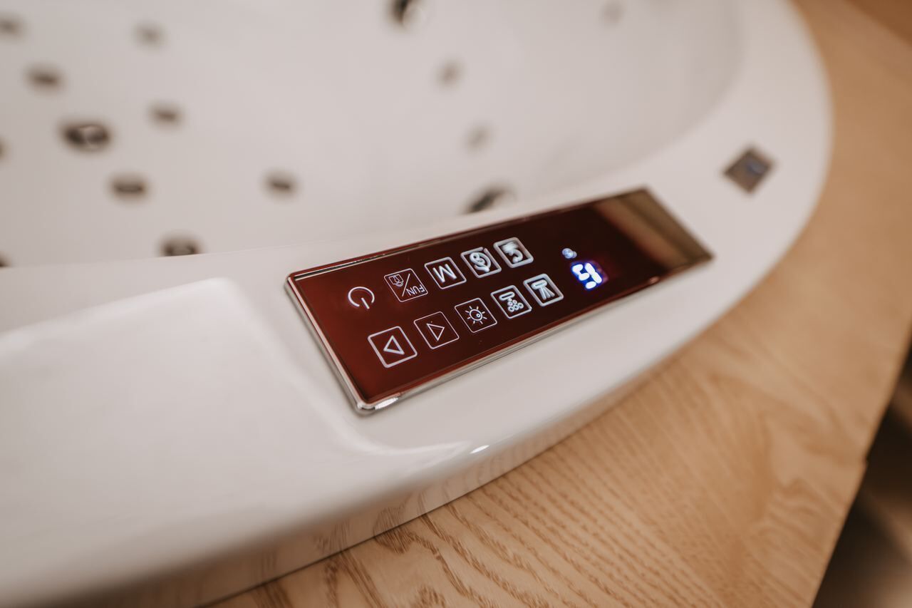 A digital control panel on a white appliance, likely a coffee maker, with various icons and a display screen.