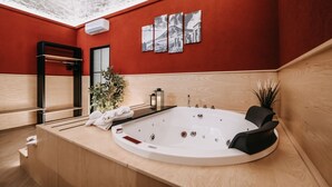 A modern bathroom with a large bathtub, wooden paneling, a mirror, and a wall-mounted air conditioner. - Michelangelo's Home Pompei (Pompei)