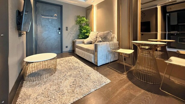 A modern living room with a sofa, a coffee table, and a small side table. - Room-luxury Condo, Chaing Mai Night Baza (Chiang Mai)