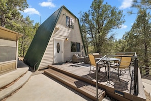 A small, A-frame wooden structure with a deck and outdoor seating area. - Zion's Emerald| Walk into East Zion| Amazing Stars (Orderville)