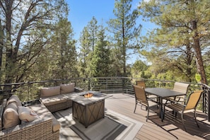 An outdoor deck with a fire pit, seating area, and a table with chairs. - Zion's Emerald| Walk into East Zion| Amazing Stars (Orderville)