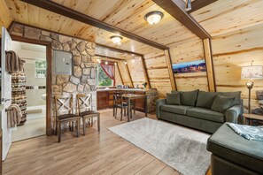 A cozy cabin interior with a stone wall, wooden furniture, and a view of a mountainous landscape. - Zion's Emerald| Walk into East Zion| Amazing Stars (Orderville)