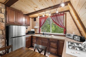 A kitchen with wooden cabinets, a stainless steel refrigerator, a microwave, a sink, and a stove. - Zion's Emerald| Walk into East Zion| Amazing Stars (Orderville)