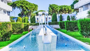 A modern hotel with a central water feature, symmetrical landscaping, and white buildings. - Green Club by Interhome (Pals)