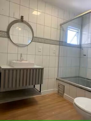 Chuveiro, toalhas de banho, sabonete, papel higiênico
