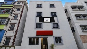 A multi-story building with a prominent sign, balconies, and a red awning. - Hotel O Metropolis Mall Kolkata (Barasat)