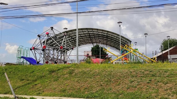 Uma roda gigante, uma montanha-russa e um parquinho com escorregadores e balanços.