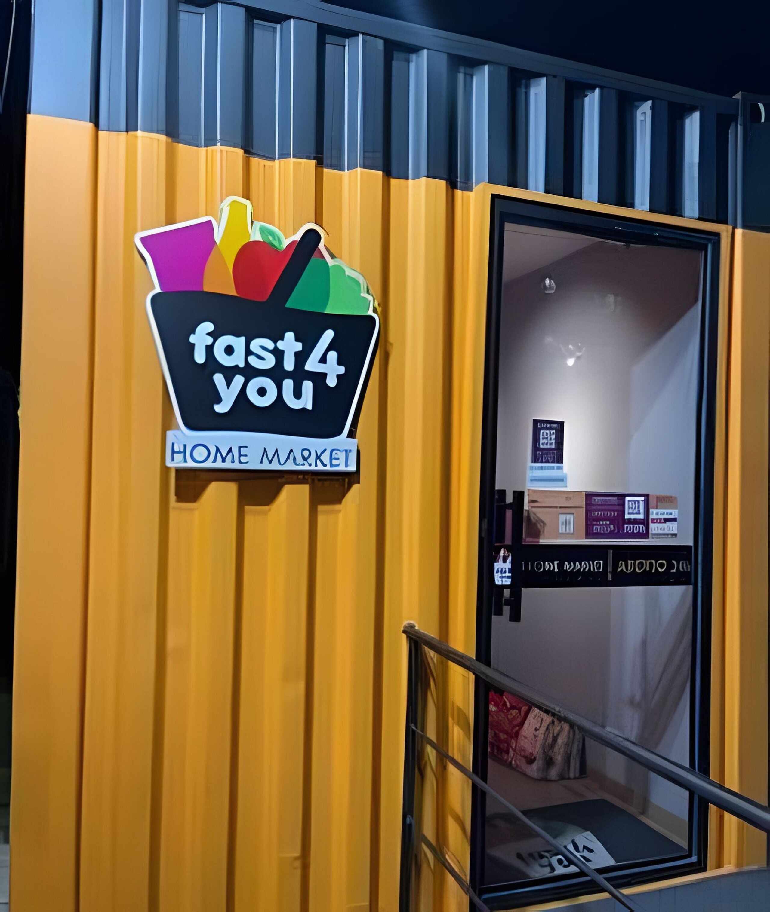 A storefront with a colorful sign reading 'fast4 you HOME MARKET' and a glass door entrance.