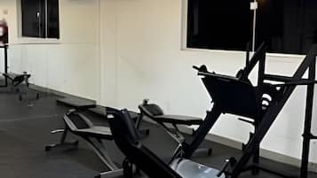 Ein Fitnessraum mit Trainingsgeräten, einem Fenster und einer Klimaanlage.
