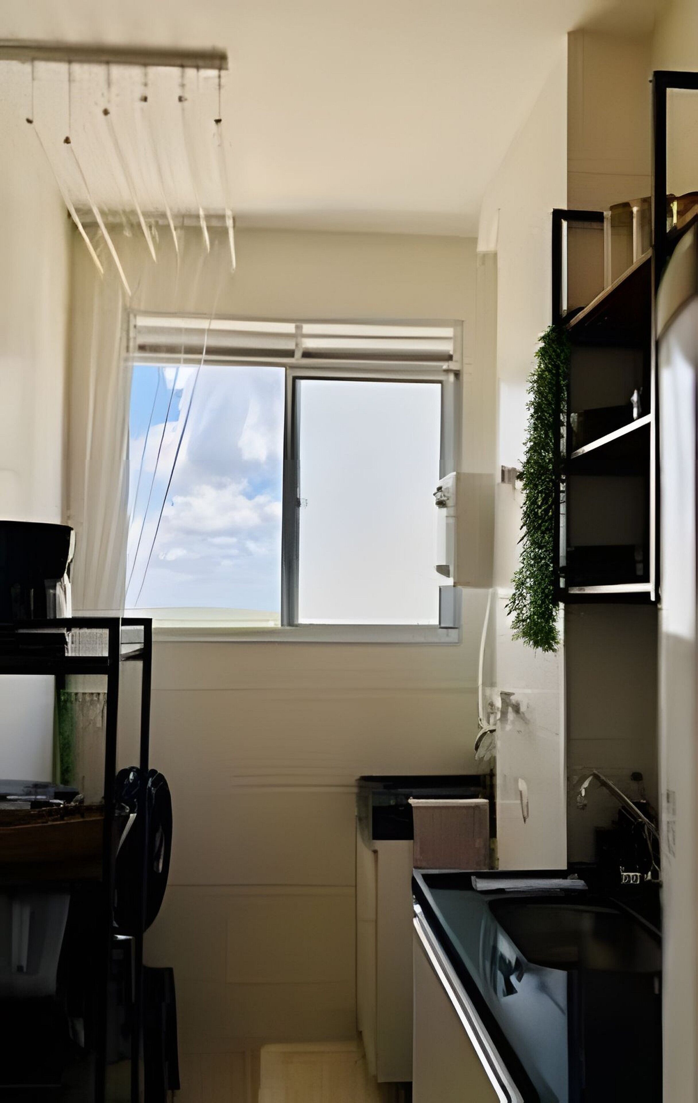 A compact kitchen with a window, a radiator, and a small sink.