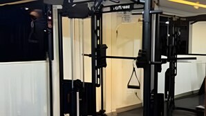 Una palestra con una rastrelliera per squat, una panca per pesi e vari pesi liberi.