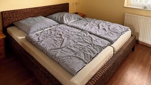 Een slaapkamer met een groot bed, een schilderij aan de muur, een raam met uitzicht en een plafondlamp.