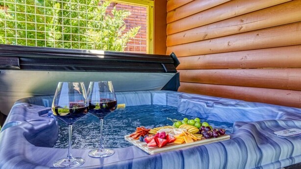 A hot tub with two glasses of red wine and a fruit platter. - New Listing Alert: Hot Tub, Views, Fireplace (Pigeon Forge)