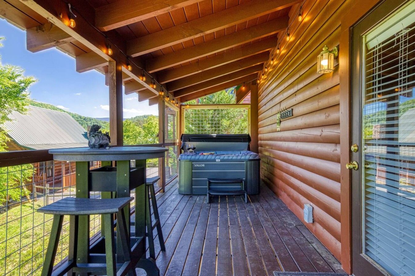 Una terraza de madera con un jacuzzi, una mesa y sillas.