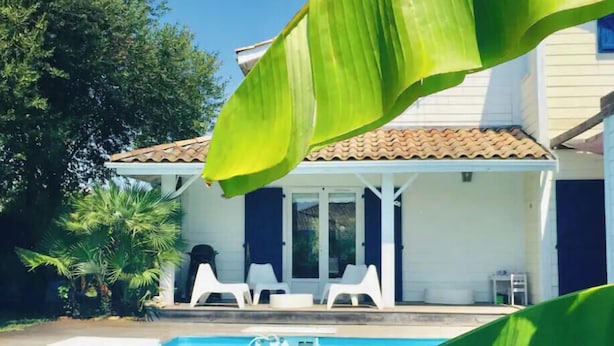 A swimming pool with a house in the background. - Private air-conditioned villa with heated pool 2nd line Bassin d'Arcachon (Gujan-Mestras)