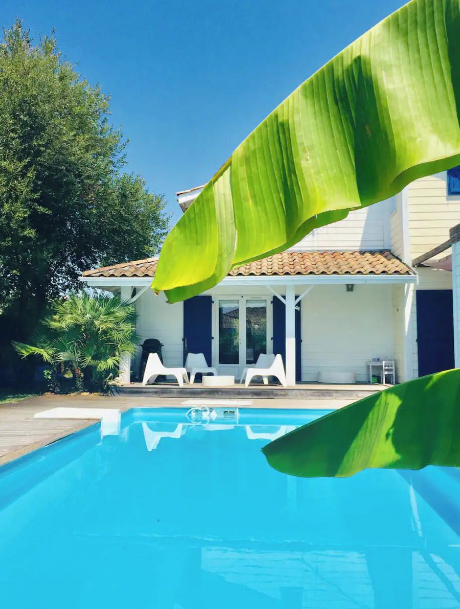 Ein Schwimmbecken mit einem Haus im Hintergrund.