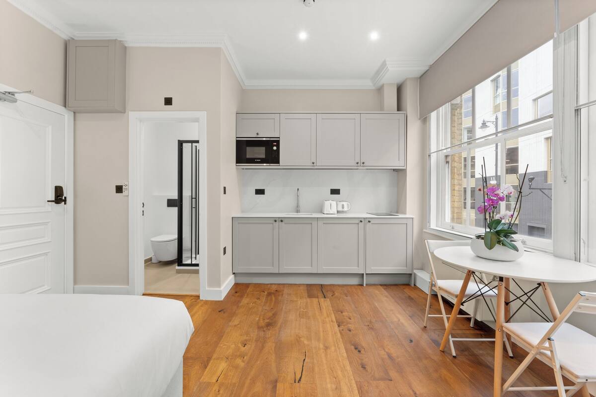 A modern kitchen with white cabinets, a microwave, and a coffee maker.