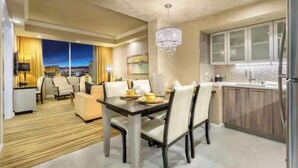 A modern dining area with a wooden floor, a chandelier, and a cityscape view. - 1BR, 1BA SUITE WITH FULL KITCHEN AMENITIES 5 MIN FROM STRIP SLEEPS 6 (Las Vegas)