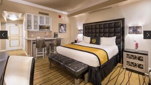A hotel room with a large bed, a desk, and a kitchenette. - 1BR, 1BA SUITE WITH FULL KITCHEN AMENITIES 5 MIN FROM STRIP SLEEPS 6 (Las Vegas)