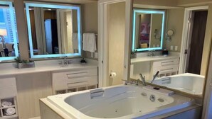 A modern bathroom with a large bathtub, a vanity with a mirror, and a toilet. - 1BR, 1BA SUITE WITH FULL KITCHEN AMENITIES 5 MIN FROM STRIP SLEEPS 6 (Las Vegas)