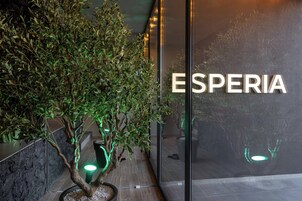 A modern building with a glass facade and the word "ESPERIA" displayed prominently.