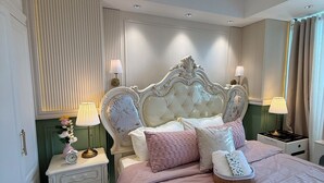 A bedroom with a large bed, two bedside tables, a chandelier, and a window with curtains. - Azure Resort 2BR Deluxe Beach & Pool View with Bathtub • 8 Pax • Smart Toilet (Parañaque)