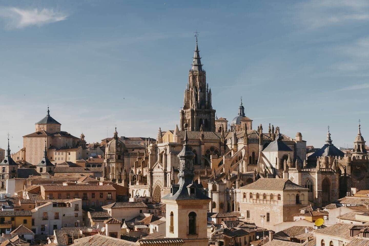 Un paisaje urbano histórico con una catedral destacada que presenta múltiples agujas y torres.