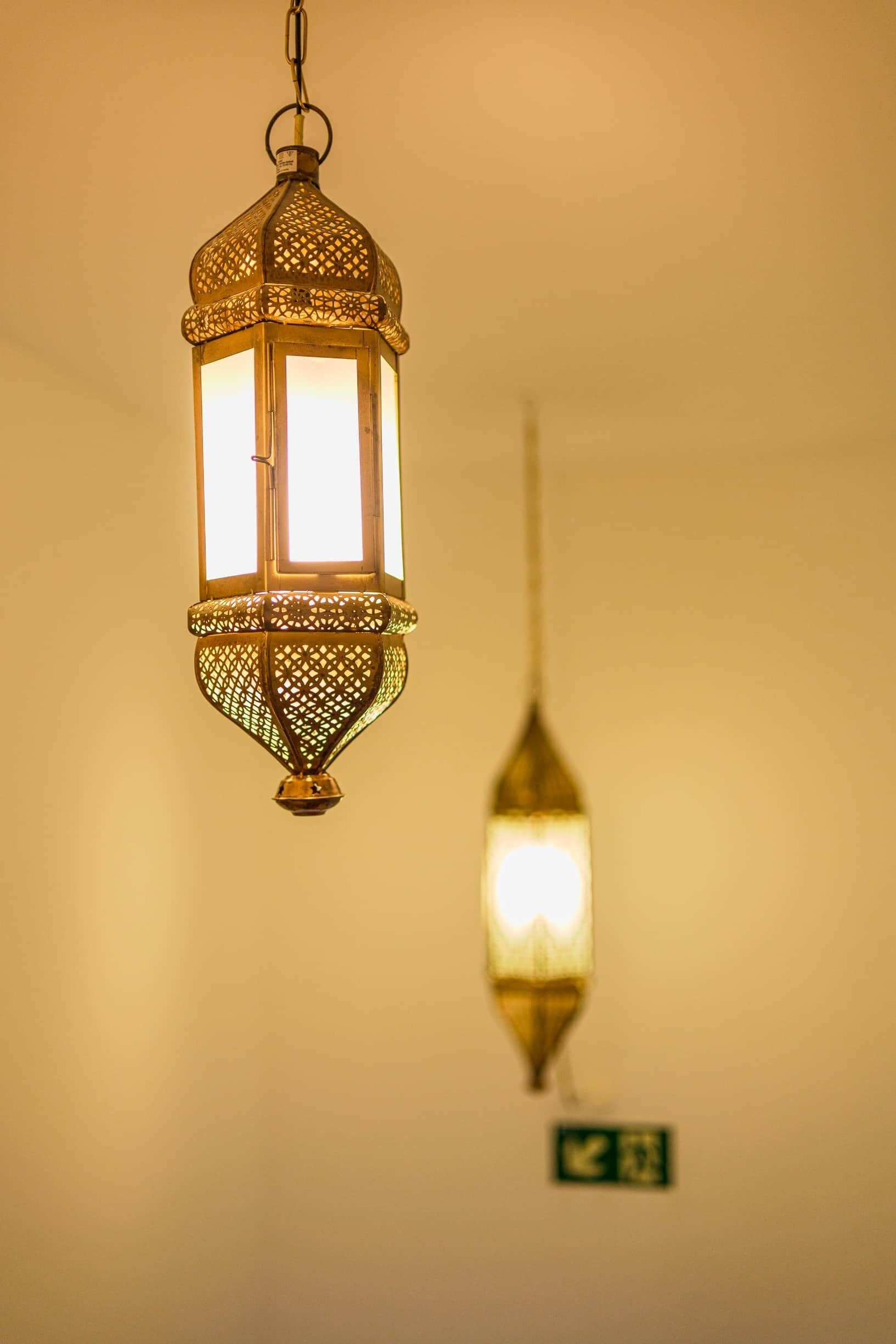 A hanging lantern with intricate lattice work and a rectangular light source.