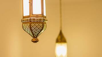 A hanging lantern with intricate lattice work and a rectangular light source.