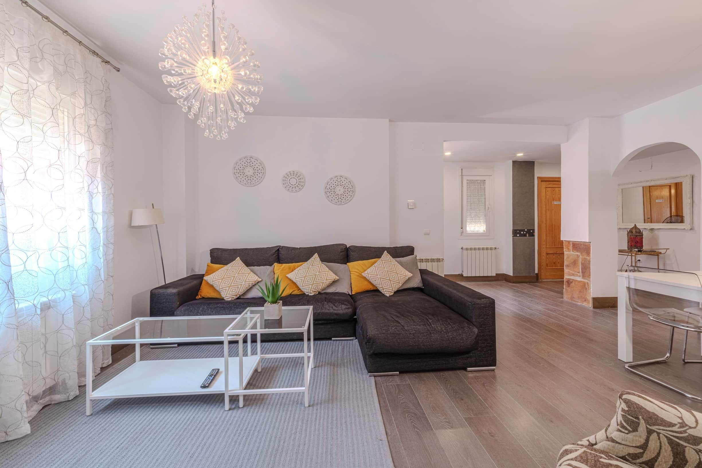 Una sala de estar con sofá, mesa de centro y elementos decorativos en la pared.