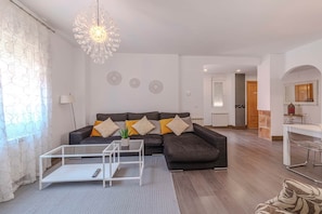 Een woonkamer met een bank, salontafel en decoratieve wandobjecten.