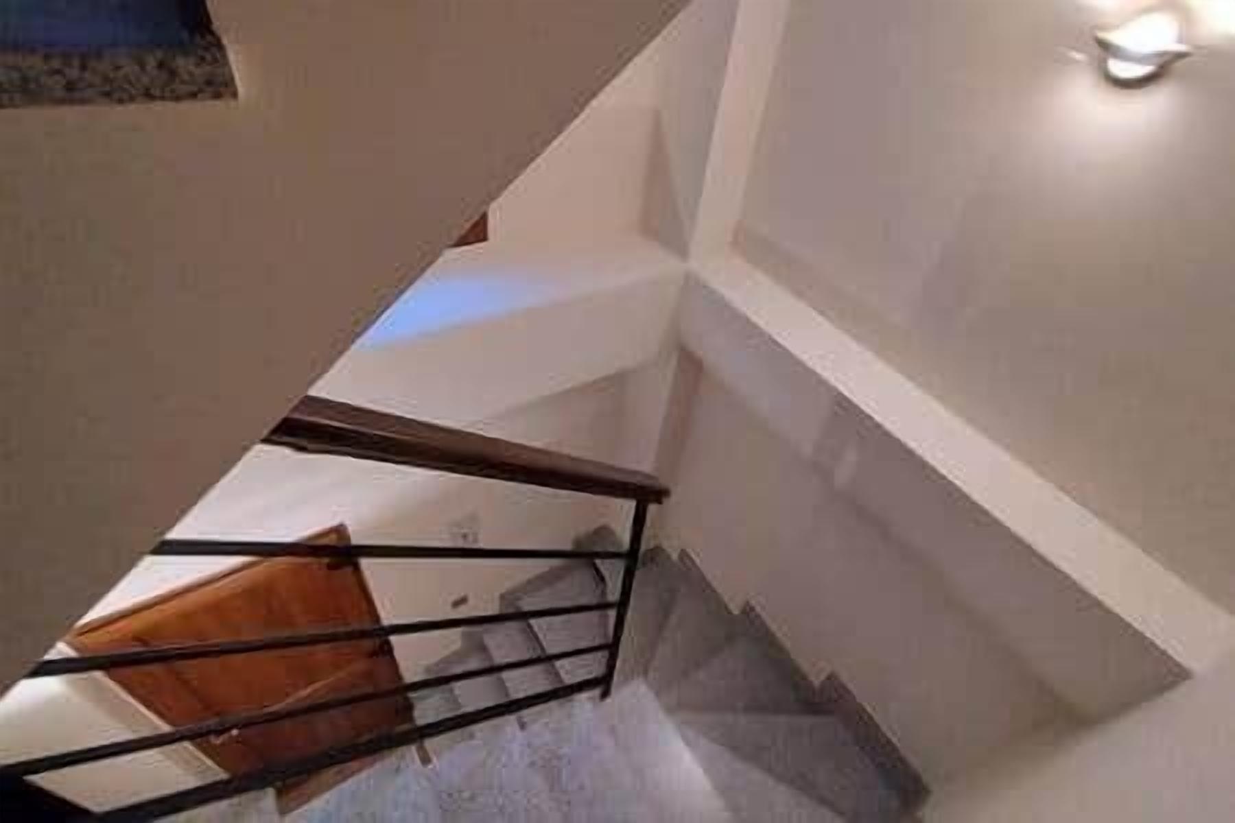 Eine Treppe mit Holzhandlauf und einer Wandleuchte.