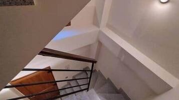 Eine Treppe mit Holzhandlauf und einer Wandleuchte.