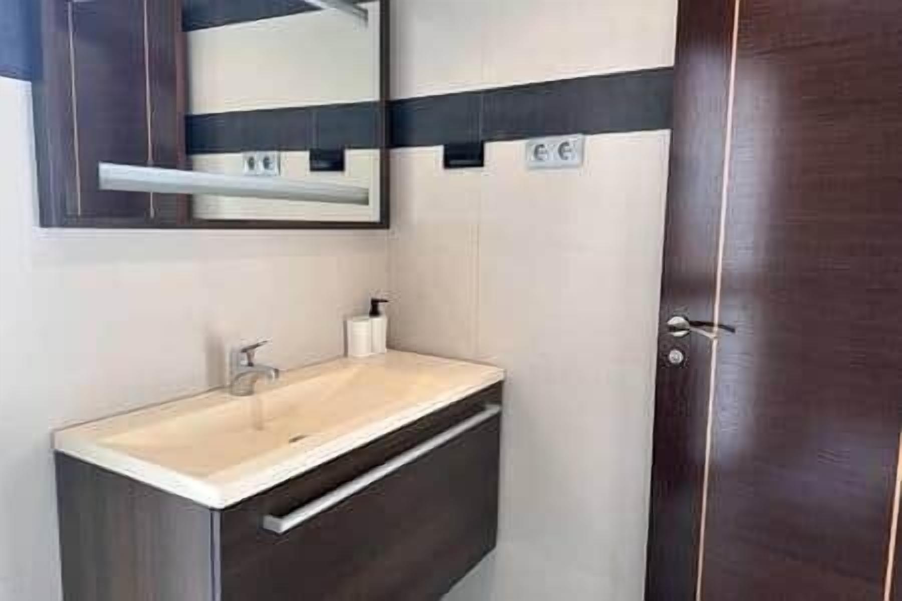 A bathroom with a sink, mirror, and towel rack.