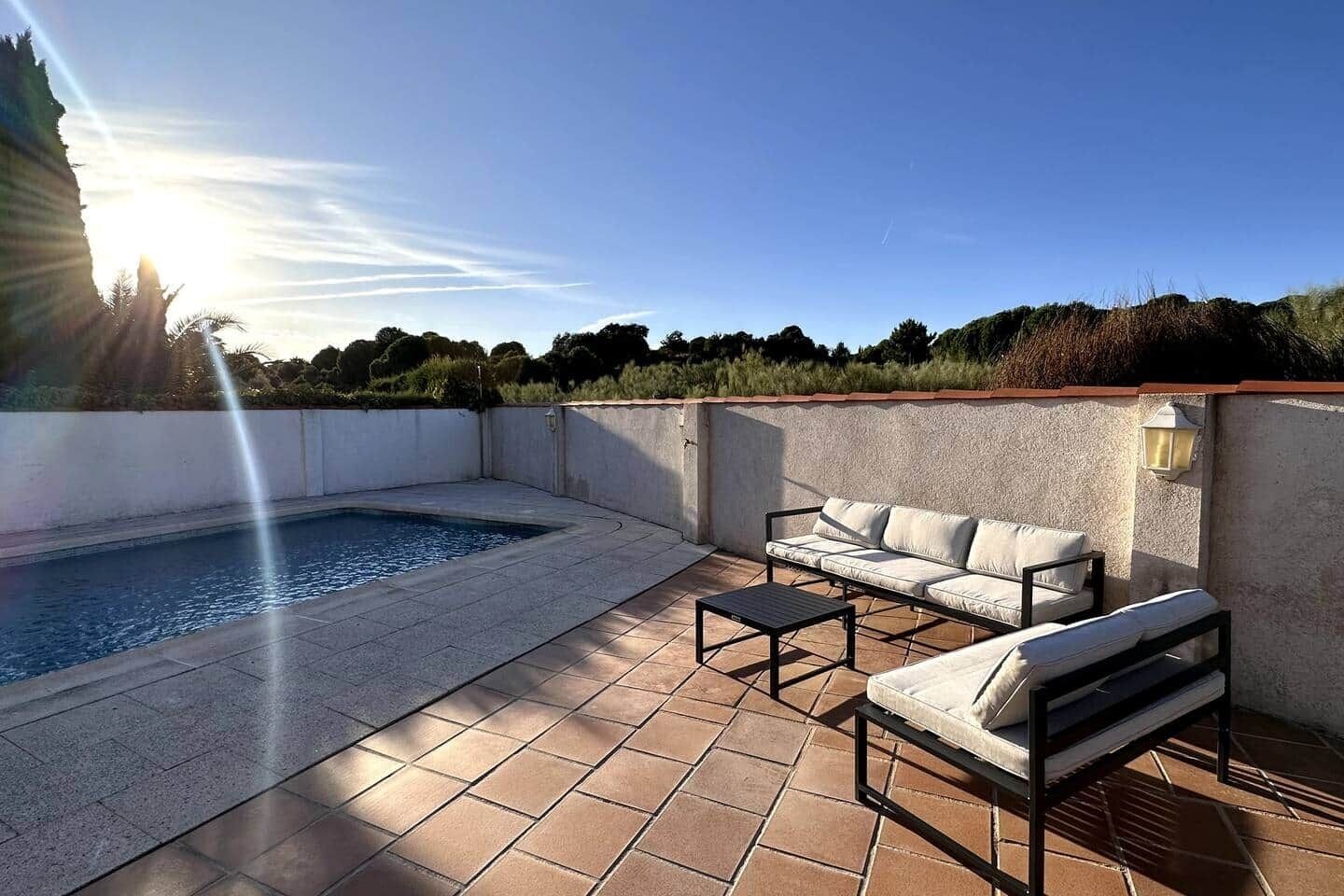 Piscina y zona chill out con sofás de exterior