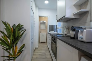 Een koffiezetapparaat/waterkoker, een koelkast, een magnetron, een oven