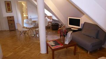 Salón con sofá cama, mesa baja y zona de comedor