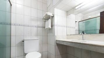 A bathroom with a toilet, a sink, and a mirror.