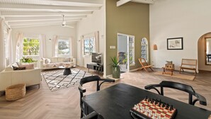 Ein geräumiges Wohnzimmer mit einem großen Holztisch, einer Couch und einem Fernseher.