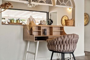 A modern workspace with a wooden desk, a cushioned chair, and a large mirror. - VillaCuraOasis Luxury villa with tropical garden, private pool, near the beach (Willemstad)