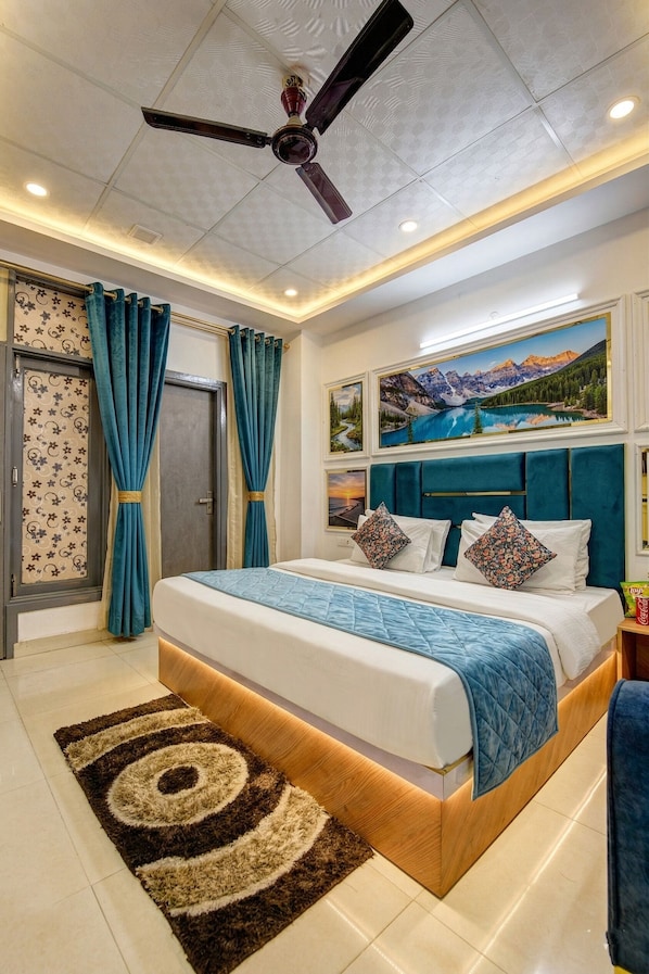 A bedroom with a bed, curtains, a ceiling fan, and a painting on the wall.