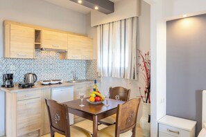 A modern kitchen with wooden cabinets, a tiled backsplash, and a dining area with a table set for two.