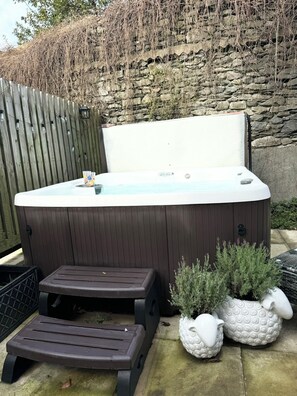 A hot tub with a wooden deck and two decorative sheep planters. - The Barn in Courtyard, 3 -Bed, Sleeps 5, Long Term Rental Available (Ulverston)