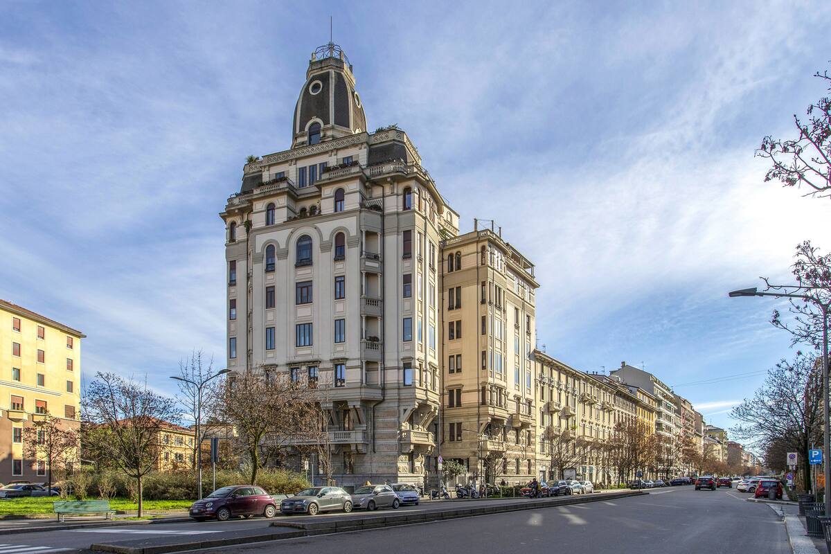 Un edificio grande e histórico con varios pisos y una torre destacada.