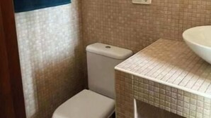 Ein kleines Badezimmer mit Toilette, Waschbecken und Handtuchhalter.