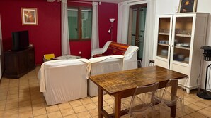 A room with a bed, a table, a cabinet, and a television. - Gite la Roseraie with Pool (Ruoms)
